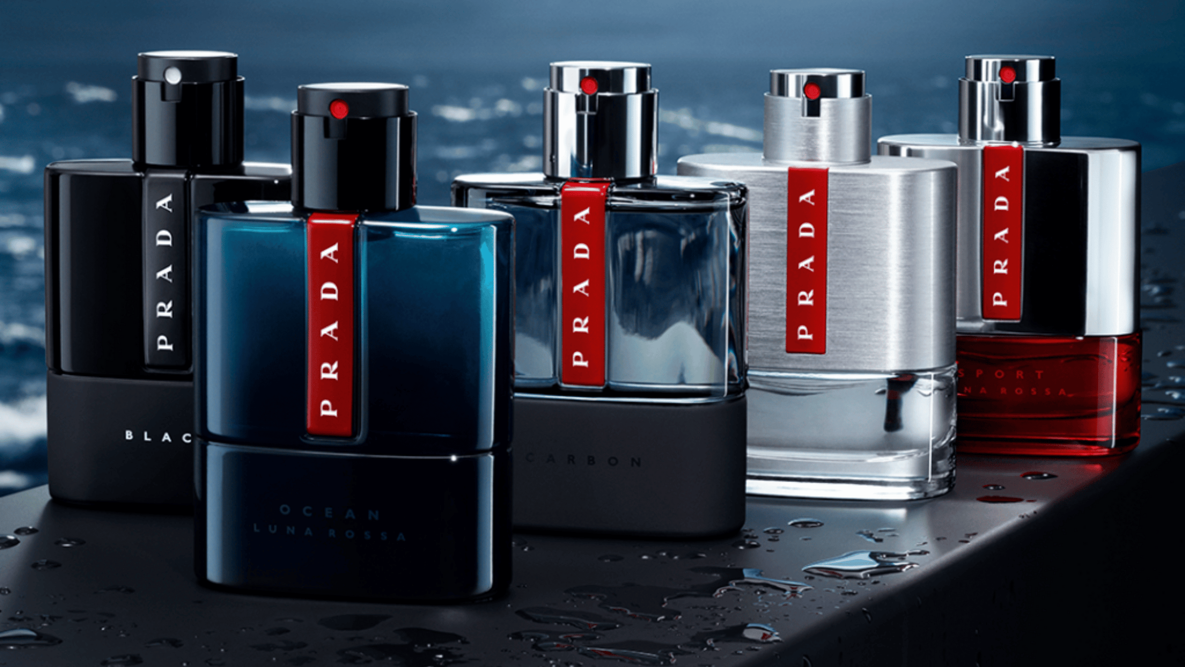 Olika prada parfymer som står uppradade med havet som bakgrund