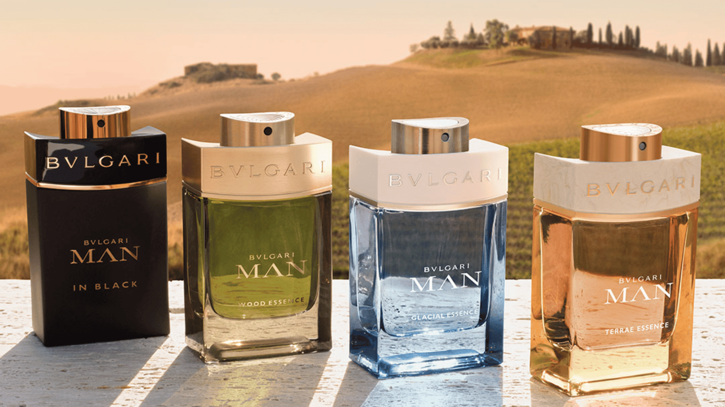 Bild på fyra parfymer från Bvlgari i ett vackert landskap. 
